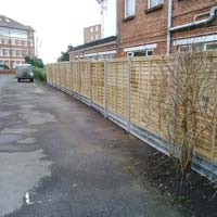 Installation of Prolap panel fence with concrete posts and concrete gravel boards